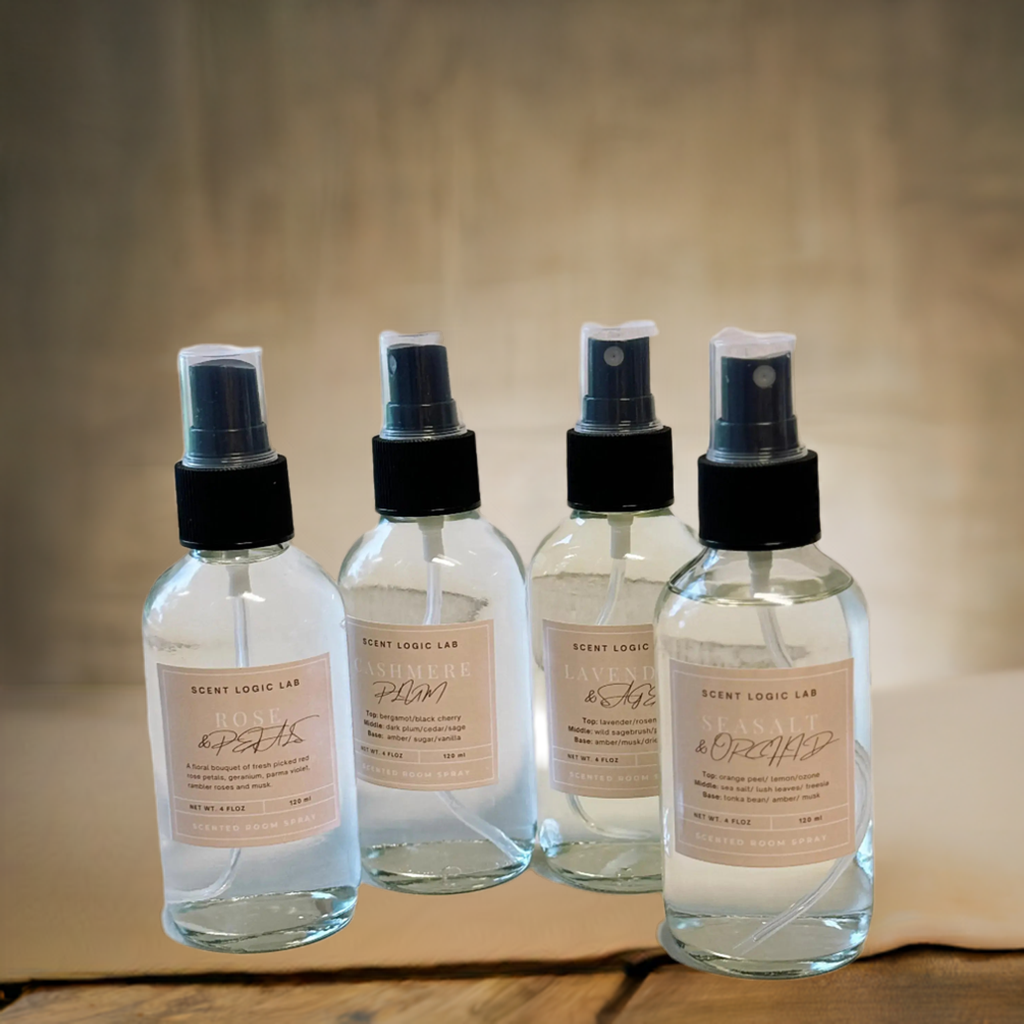 Four spray bottles with labels on a wooden surface and beige background